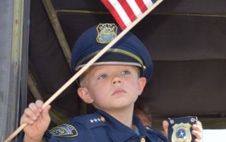 Child Waving American Flag inside Parade Vehicle
